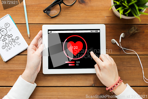 Image of close up of woman with tablet pc on wooden table