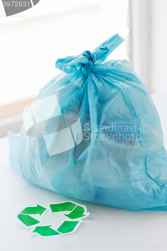 Image of close up of rubbish bag with green recycle symbol
