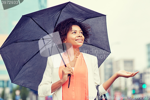 Image of happy african american businesswoman with umbrella