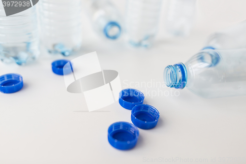 Image of close up of empty water bottles and caps on table