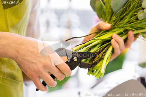 Image of close up of florist man with flowers and pruner