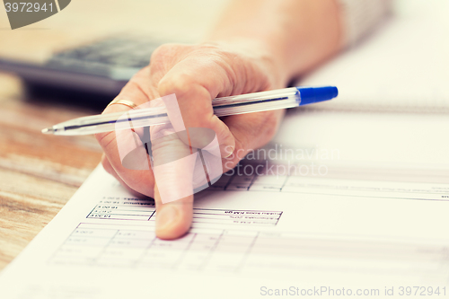 Image of close up of senior woman hand checking bill