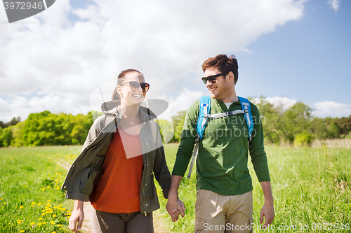 Image of happy couple with backpacks hiking outdoors