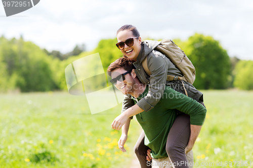 Image of happy couple with backpacks having fun outdoors