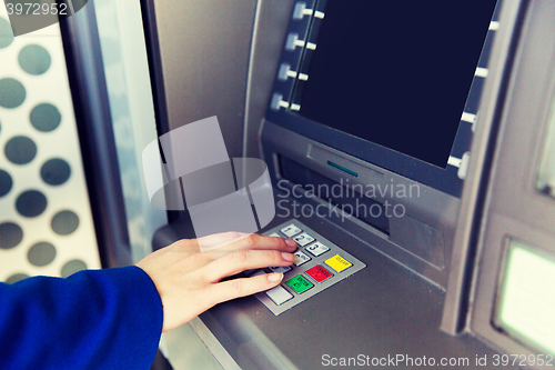 Image of close up of hand entering pin code at cash machine