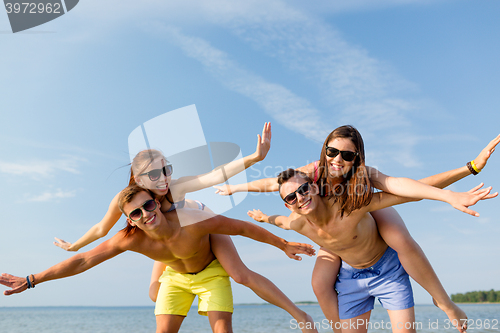 Image of smiling friends having fun on summer beach