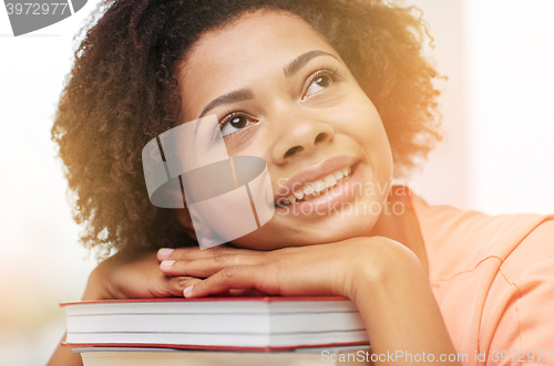 Image of happy african student girl with books at home