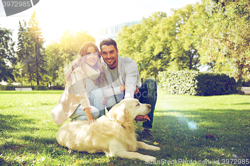 Image of happy couple with labrador dog walking in city