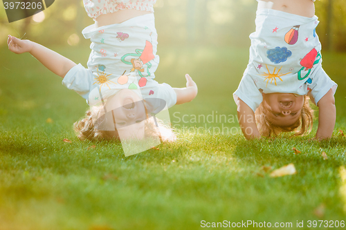 Image of The two little baby girls hanging upside down