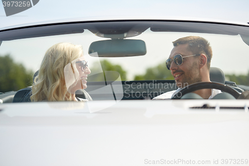 Image of happy man and woman driving in cabriolet car