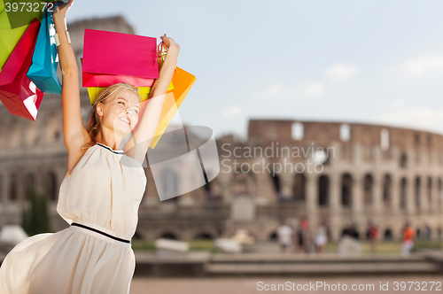 Image of happy woman with shopping bags over coliseum