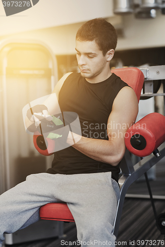 Image of young man with smartphone in gym