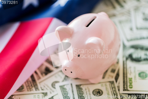 Image of close up of american flag, piggy bank and money