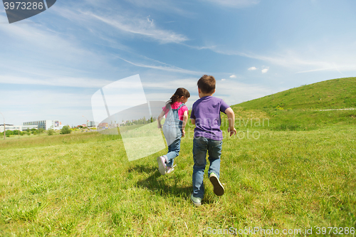 Image of happy little boy and girl running outdoors