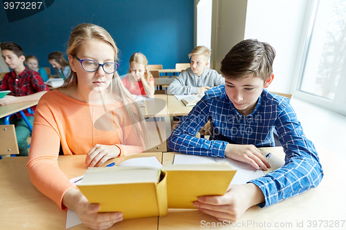 Image of students reading book at school lesson