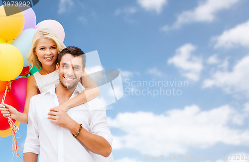 Image of happy couple with balloons over blue sky