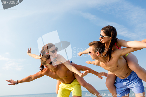 Image of smiling friends having fun on summer beach