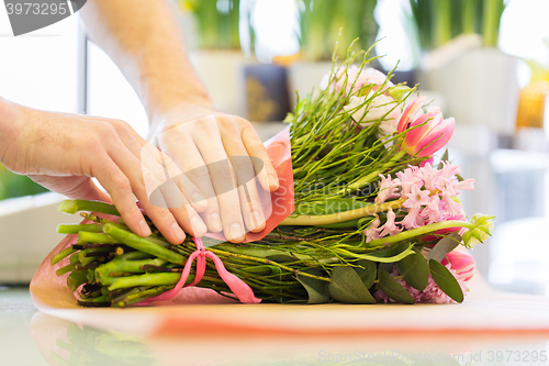 Image of florist wrapping flowers in paper at flower shop