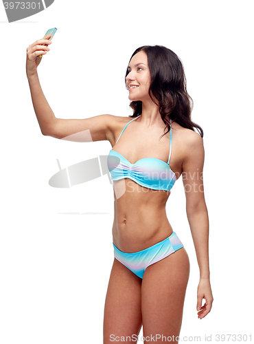 Image of woman in swimsuit taking selfie with smatphone