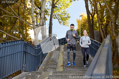 Image of happy couple running downstairs in city