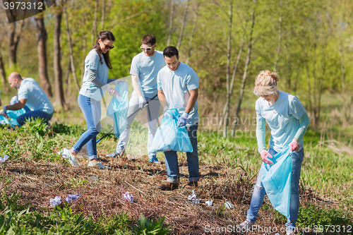 Image of volunteers with garbage bags cleaning park area