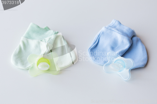 Image of close up of baby mittens and soothers for twins