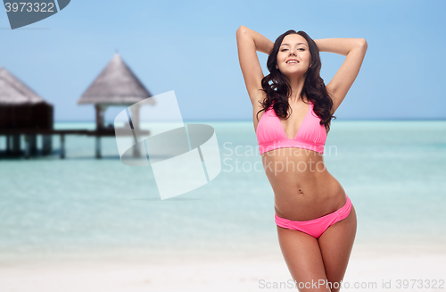 Image of happy young woman in pink bikini swimsuit