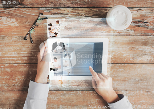 Image of close up of hands with tablet pc and web page