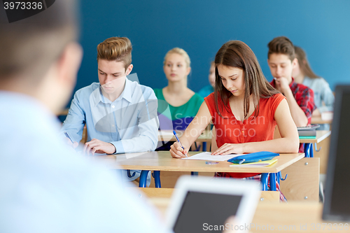 Image of group of students with books writing school test