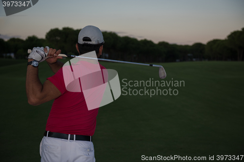 Image of golfer hitting a sand bunker shot on sunset