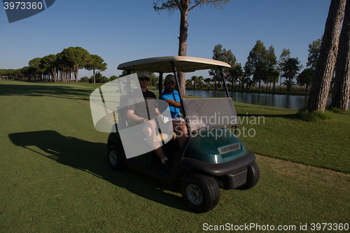 Image of golf players driving cart at course