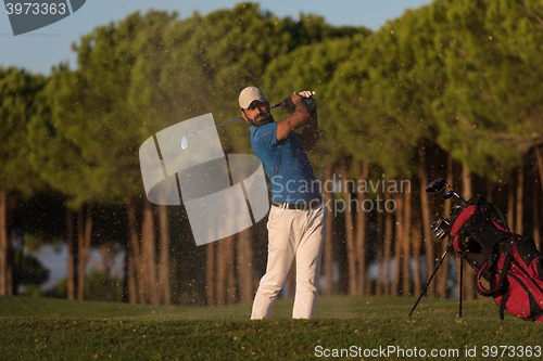 Image of golfer hitting a sand bunker shot on sunset