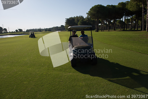 Image of golf players driving cart at course