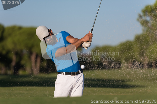 Image of pro golfer hitting a sand bunker shot