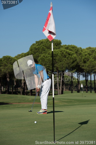 Image of golf player hitting shot at sunny day