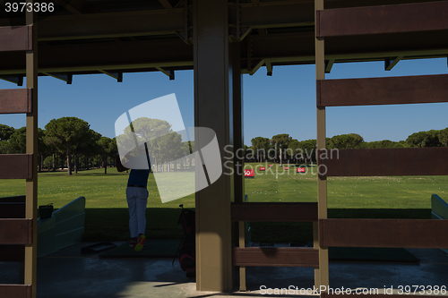 Image of golf player practicing shot on training