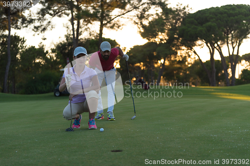 Image of couple on golf course at sunset