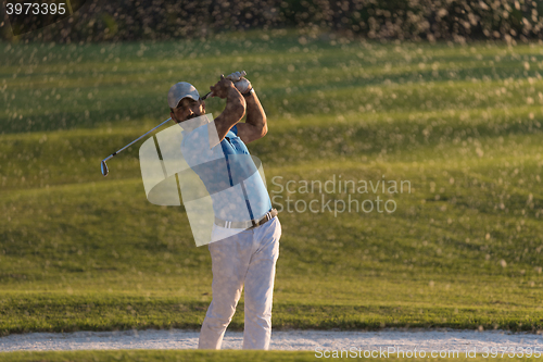 Image of golfer hitting a sand bunker shot on sunset