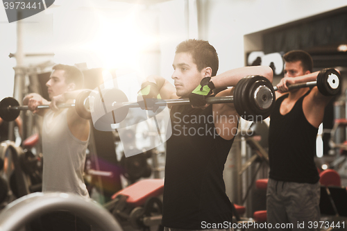 Image of group of men with barbells in gym