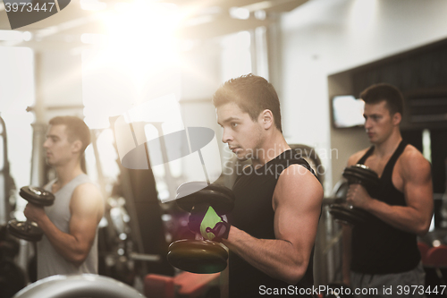 Image of group of men with dumbbells in gym