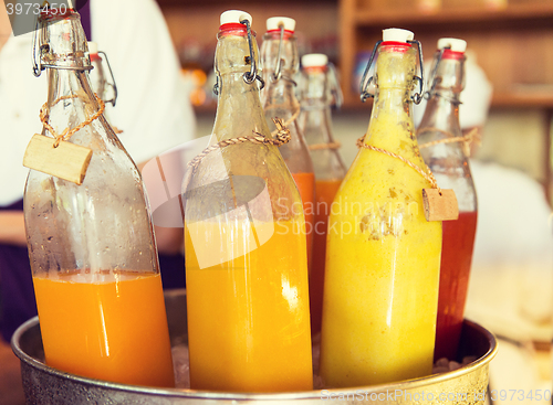 Image of bottles of juice in ice bucket at market