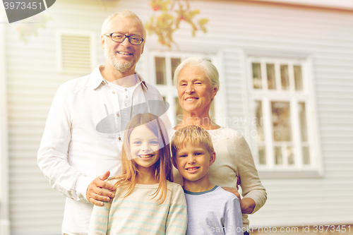 Image of happy family in front of house outdoors