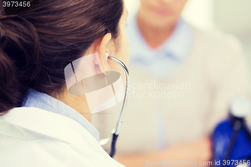 Image of doctor with tonometer and senior woman at hospital