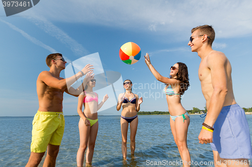 Image of smiling friends in sunglasses on summer beach