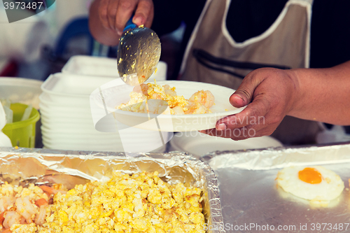 Image of close up of hands with wok at street market