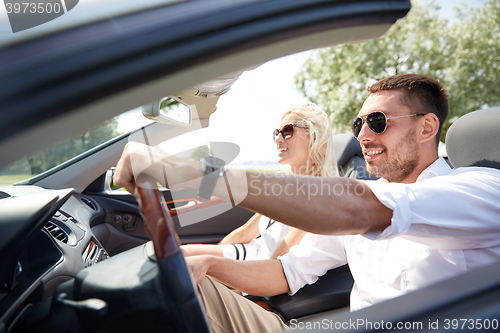 Image of happy man and woman driving in cabriolet car