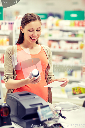 Image of happy pregnant woman with medication at pharmacy