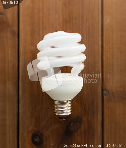 Image of close up of energy saving lighting bulb on wood
