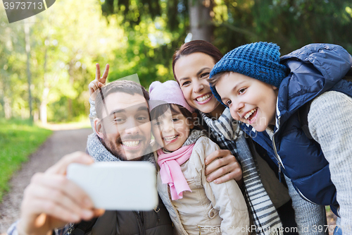 Image of family with backpacks taking selfie by smartphone