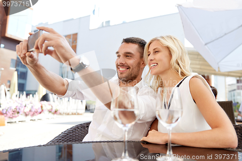 Image of couple taking selfie with smatphone at restaurant